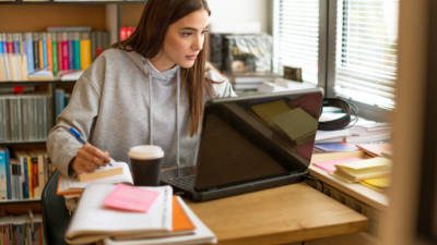 Female student learning online in library